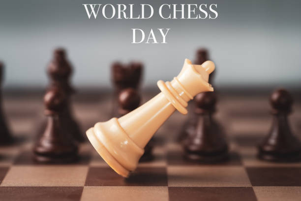 white chess queen falling on chess board world chess day .
